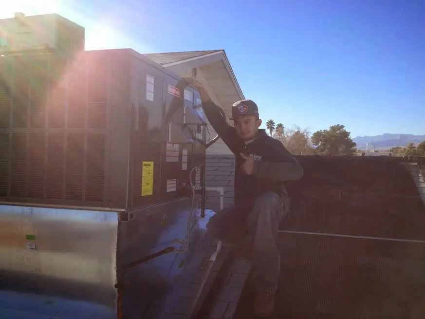 HVAC technician performing Air Duct Cleaning on a rooftop unit in South Salt Lake