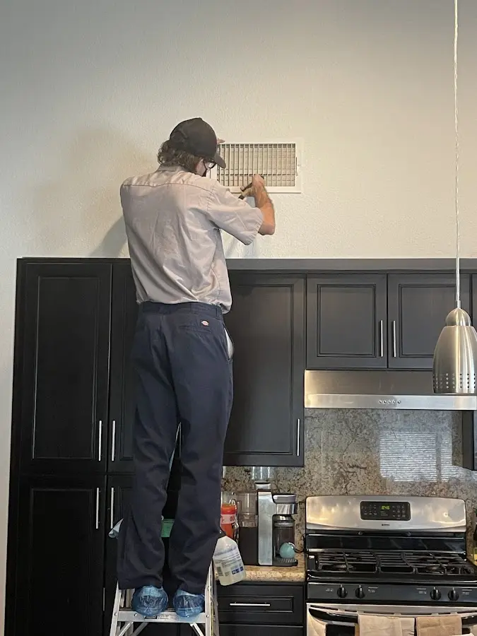 Technician inspecting an air vent during HVAC service in South Salt Lake